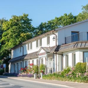 eine Reihe von Häusern auf einer Straße mit Blumen in der Unterkunft Landhaus Schulze-Hamann - Hotel garni - in Blunk