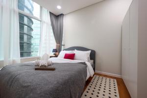 a bedroom with a bed and a large window at Sky Suites KLCC By Calm Sojourn in Kuala Lumpur