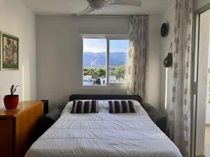 1 dormitorio con cama y ventana grande en Piso a pie de playa con piscina y vistas al mar, en Benicàssim