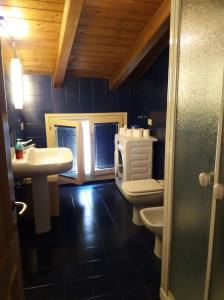 La salle de bains est pourvue de toilettes blanches et d'un lavabo. dans l'établissement De' Pepoli Rooms & Apartments, à Bologne