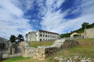 eine alte Steinmauer vor einem Gebäude in der Unterkunft Campus San Francesco in Conegliano