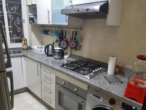 a kitchen with a stove top oven next to a sink at Beautiful Apartment Holiday with Terrace, Casablanca in Casablanca