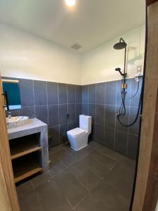 ein Bad mit einer Dusche, einem WC und einem Waschbecken in der Unterkunft House Bok Bowie in Koh Rong Sanloem