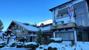 a hotel in the mountains with snow on the ground at Hotel Regina Delle Dolomiti in Panchia