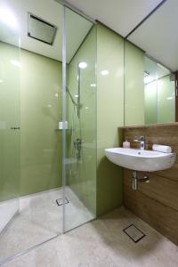 a bathroom with a sink and a glass shower at Sky Suites KLCC By Calm Sojourn in Kuala Lumpur