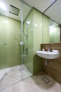 a bathroom with a sink and a glass shower at Sky Suites KLCC By Calm Sojourn in Kuala Lumpur +40 photos