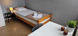 ein kleines Bett in einem Zimmer mit einem Tisch in der Unterkunft Näsbygården in Storvik