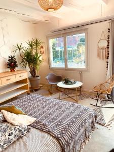 a bedroom with a bed and a table and a window at Gîte Mozart - Marché de Noël in Colmar