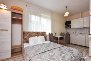 a bedroom with a bed and a kitchen with a table at OPTIMISTAS in Palanga
