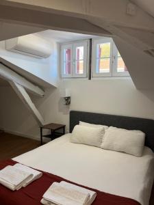 Schlafzimmer mit einem Bett mit weißer Bettwäsche und Fenstern in der Unterkunft Hostel 20 Bayonne in Bayonne