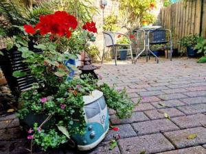 a garden with flowers in a pot on a patio at Jackdaw Cottage-Beautiful Cottage, Town Centre in Wimborne Minster