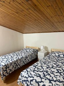 a bedroom with two beds and a wooden ceiling at La mansarda di melo in Catania