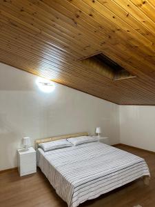 a bedroom with a large bed with a wooden ceiling at La mansarda di melo in Catania