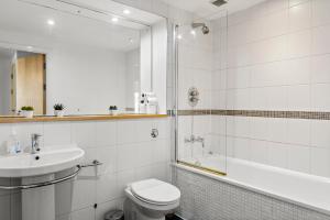 a bathroom with a toilet and a sink and a tub at Enchanting Bristol Abode -Sleeps 6 with Balcony! in Bristol
