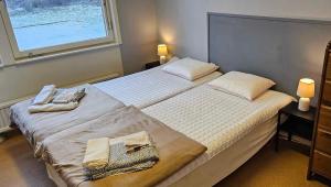 a bedroom with a large bed with two towels on it at Näsbygården in Storvik