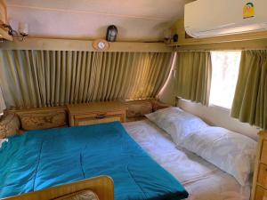 1 dormitorio con 1 cama en la parte trasera de una caravana en Moon Village Khaoyai Holiday Home, en Pong Talong