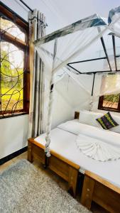 two beds in a room with a window at Sophie Homestay in Moshi