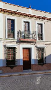 a white building with balconies and doors on a street at Una casa azul en el sur in Manzanilla