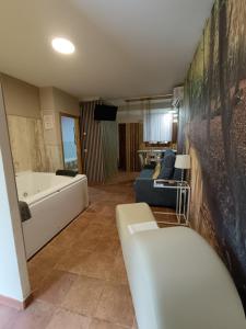 uma sala de estar com uma banheira e um sofá em The Vanilla Suite em Chinchón