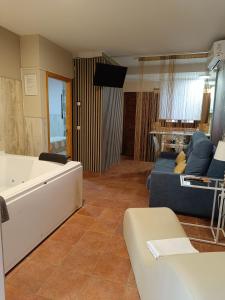 a living room with a tub and a couch at The Vanilla Suite in Chinchón