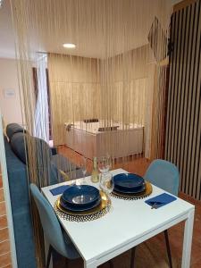 a white table with blue plates and glasses on it at The Vanilla Suite in Chinchón