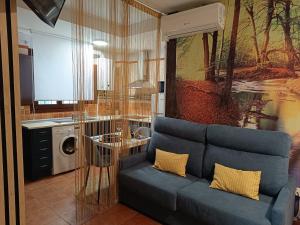 a living room with a couch and a washing machine at The Vanilla Suite in Chinchón