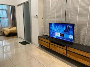 a living room with a flat screen tv on a dresser at ITCC Manhattan Suites by Blossom37 in Donggongon