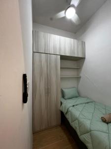 a small bedroom with a bed and a cabinet at ITCC Manhattan Suites by Blossom37 in Donggongon