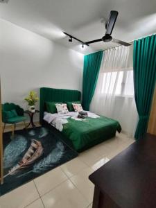 een slaapkamer met een groen bed en een stoel bij Lovely Stay By Cinta in Sepang
