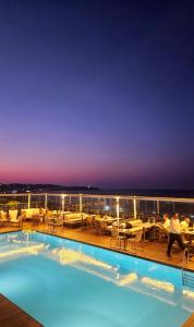 a swimming pool on the deck of a cruise ship at night at Dar El Marsa Hotel & Spa in La Marsa