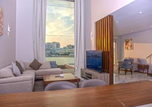 a living room with a couch and a tv at The Sea Loft Boutique Chalets in Manama