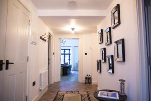 un pasillo con paredes blancas y una puerta con fotografías en The Penthouse at Mercers Croft en Stratford-upon-Avon