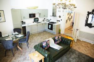 a living room with a couch and a kitchen at The Penthouse at Mercers Croft in Stratford-upon-Avon