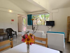 ChachagüíHOTEL PANORAMA SOL的房间里有一张桌子，桌子上放着一瓶花。