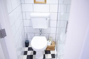 a white toilet in a bathroom with a checkered floor at The Penthouse at Mercers Croft in Stratford-upon-Avon +22 photos