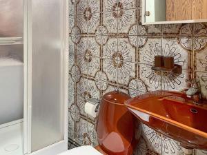 La salle de bains est pourvue d'un lavabo en cuivre et de toilettes. dans l'établissement Holiday home BROMMA II, à Stockholm