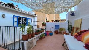 einen Balkon mit Topfpflanzen auf einem Gebäude in der Unterkunft Habitación en centro histórico in Málaga