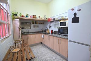 una piccola cucina con frigorifero e panca in legno di Habitación en centro histórico a Málaga