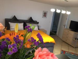 sypialnia z łóżkiem z kwiatami na pierwszym planie w obiekcie Magie Du Léman w mieście Blonay