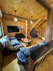 uma sala de estar num chalé de madeira com um sofá em Guest House Pid Dubom Карпати Під Дубом em Skole