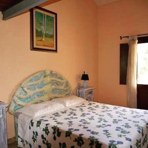 una camera con un letto con una coperta blu e bianca di Hotel Valle del Cedrino a Galtellì