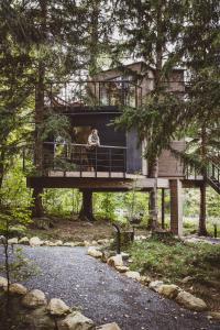 a woman sitting on a deck of a tree house at Treehouse Karpacz in Karpacz