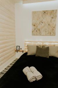 a bedroom with a black bed with towels on it at Sauna apartment / Pirts apartamenti in Talsi