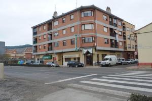 a large brick building with cars parked in front of it at Hostal Venecia in Azagra