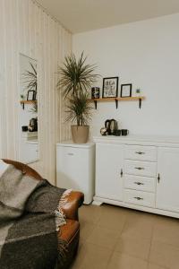 a living room with a couch and a white cabinet at Sauna apartment / Pirts apartamenti in Talsi