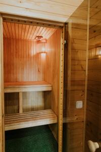 a sauna with wooden walls and a green floor at Sauna apartment / Pirts apartamenti in Talsi