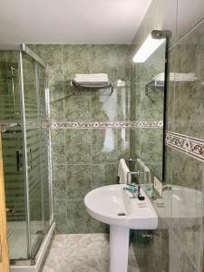y baño con lavabo y ducha. en Apartamentos Balcón de Maro, en Maro