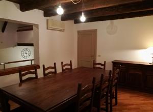 una sala da pranzo con tavolo e sedie in legno di De' Pepoli Rooms & Apartments a Bologna