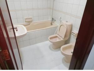 W łazience znajduje się toaleta, wanna i umywalka. w obiekcie Corniche AD - Stunning Room w Abu Zabi