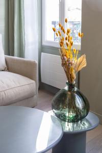 un vaso con fiori su un tavolo in soggiorno di The Liberty Green Suite a Parigi